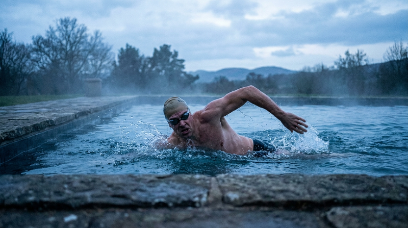Athlete swimming freestyle at dawn during selection-style training