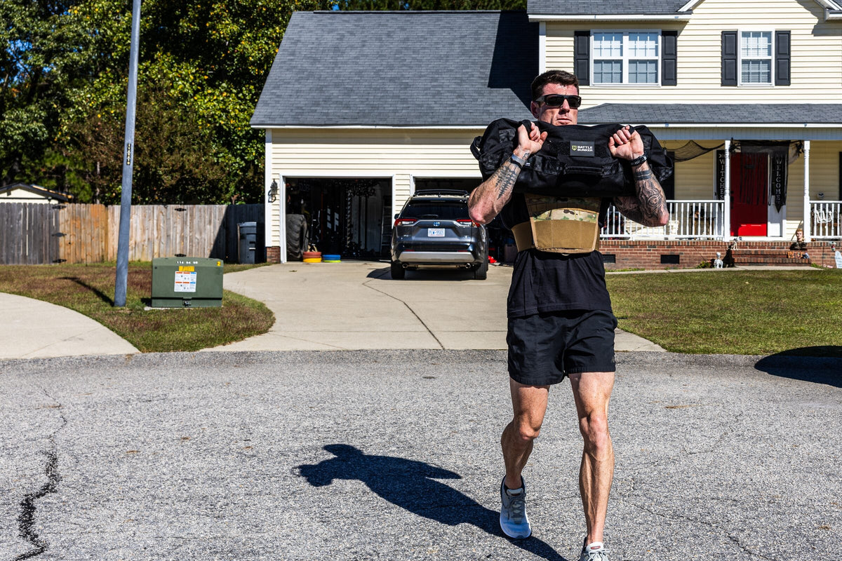 Dan Fahey of Gritty Soldier walking with a sandbag across his shoulders