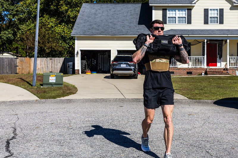 Dan Fahey of Gritty Soldier walking with a sandbag across his shoulders