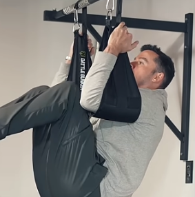 Michael Eckert training on a pull-up bar with ab straps