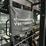 Battle Bunker gym banner with motivational text Stronger Than Yesterday inside fitness center with weights