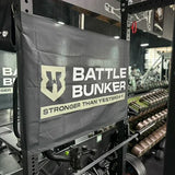 Battle Bunker gym banner with strength training equipment and dumbbells in fitness center