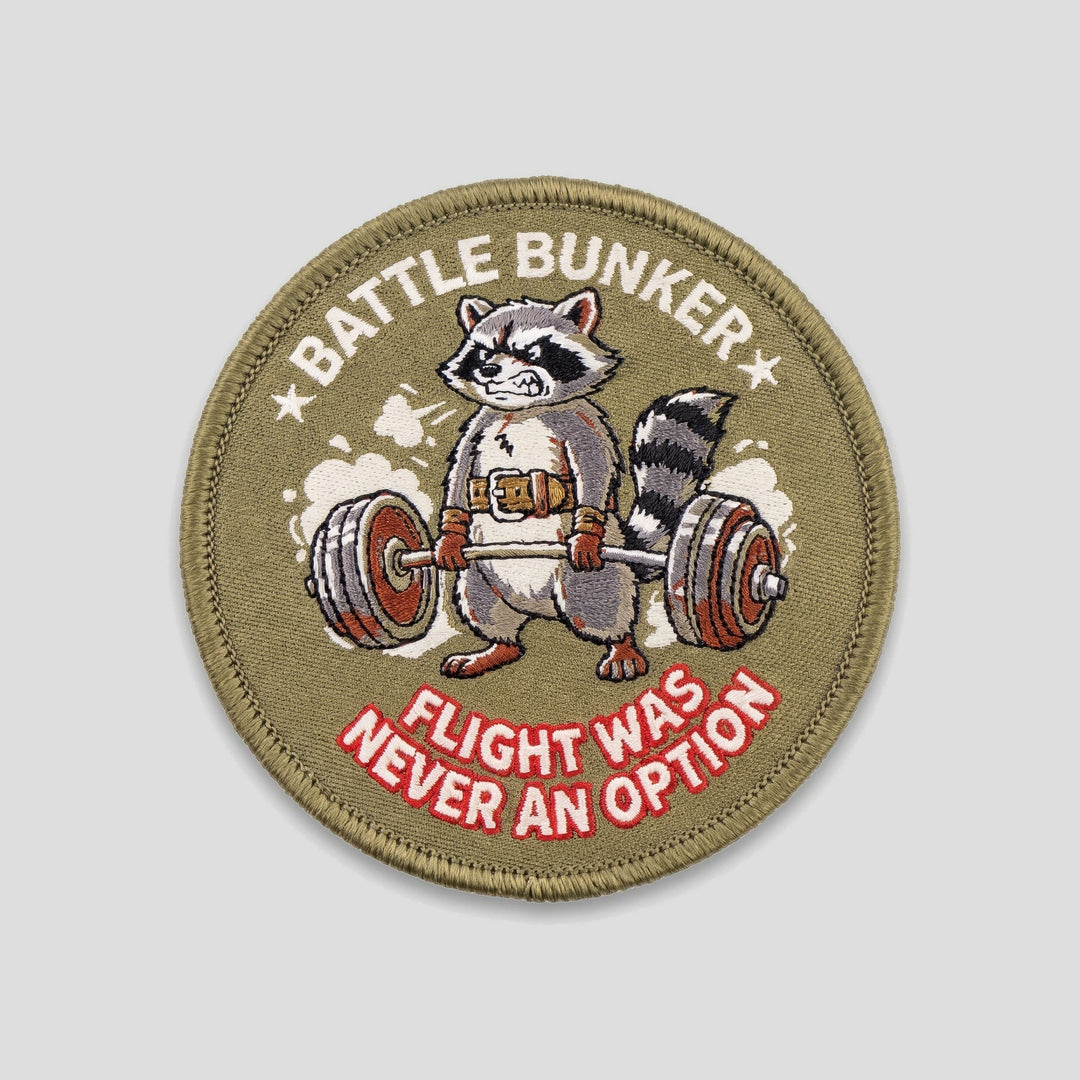 Flight Was Never An Option Patch, round olive patch with raccoon deadlifting a barbell