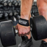 Close-up of hand wearing Battle Bunker battle straps gripping a heavy dumbbell in gym setting
