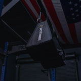 Black Battlebunker weight bag hanging in gym with American flag in background