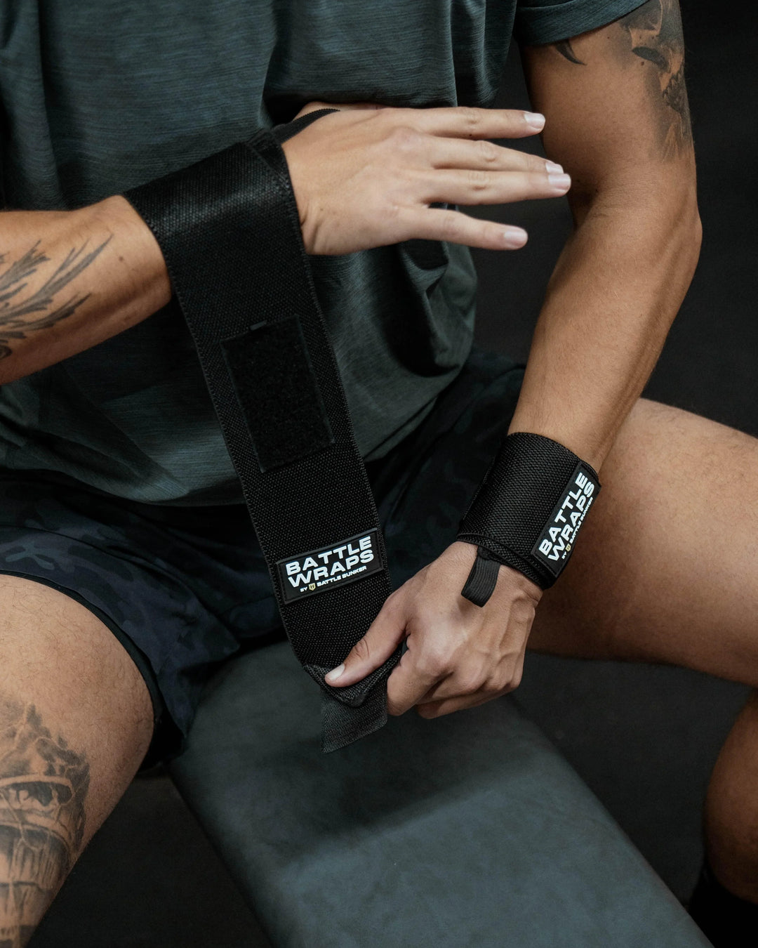 Athlete wearing black Battle Wraps wrist supports by Battle Bunker, preparing for workout on bench