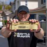 Man holding three beige Battle Bands resistance bands by Battle Bunker with different weight levels outdoors