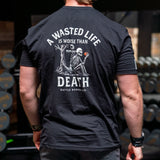 Man wearing black Battle Bunker T-shirt with skeleton and apple design, text about life and death