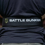 Back view of person wearing a black Battle Bunker branded weightlifting belt