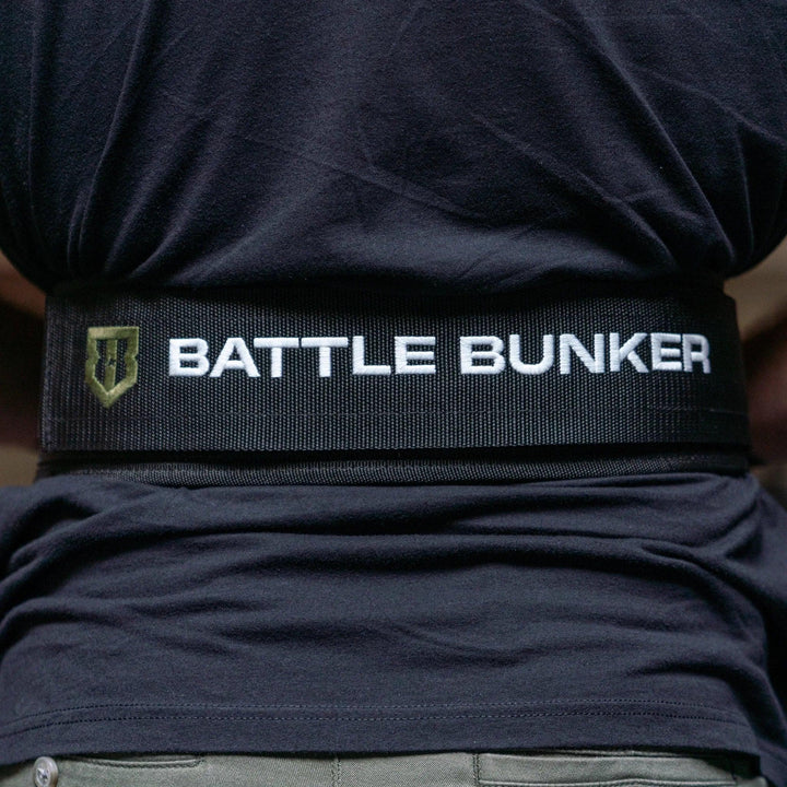 Back view of person wearing a black Battle Bunker branded weightlifting belt