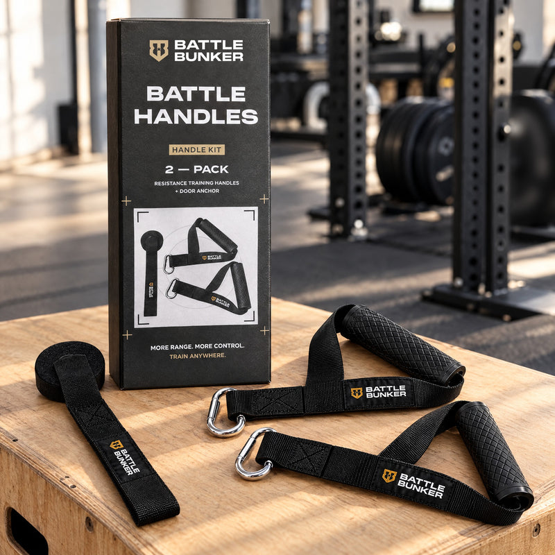 Battle Bunker Battle Handles box on a wooden plyo box in a garage gym, with both resistance training handles and the door anchor beside it