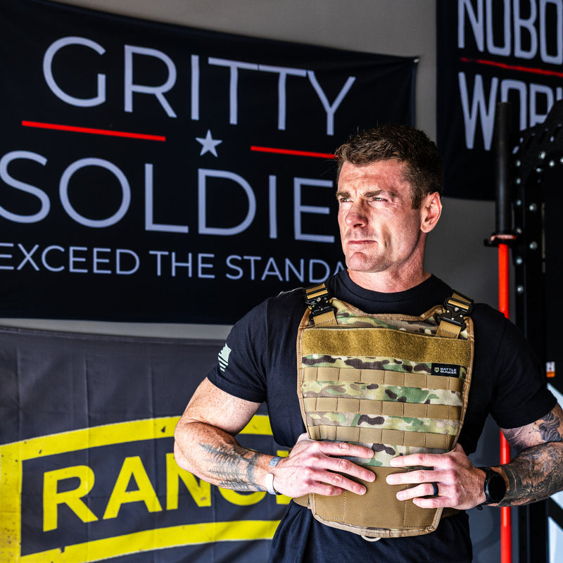 Dan Fahey of Gritty Soldier wearing the Battle Bunker Hybrid Weight Vest MK2 in camo in his garage gym