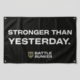 Black flag with white text Stronger Than Yesterday and Battle Bunker logo
