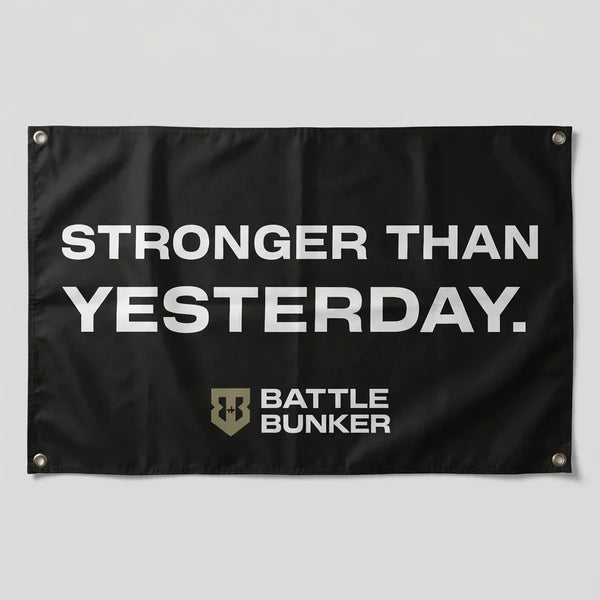 Black flag with white text Stronger Than Yesterday and Battle Bunker logo