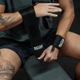 Close-up of person wearing and adjusting black Battle Wraps wrist straps by Battle Bunker